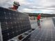 Workers install photovoltaic solar panels on the roof of the National Renewable Energy Laboratory's Research Support Facility in Golden, Colo. in 2013. (Source: U.S. Department of Energy)
